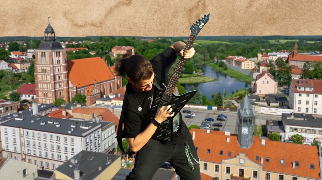 Mężczyzna grający na gitarze na tle miasta.