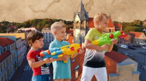 Trzech chłopców bawiących się na dachu z wyrzutniami wodnymi.