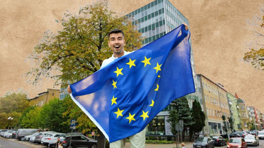 Mężczyzna trzyma flagę Unii Europejskiej.
