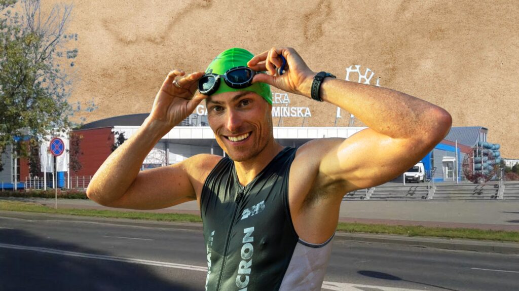 Mężczyzna w czepku pływackim trzyma okulary.