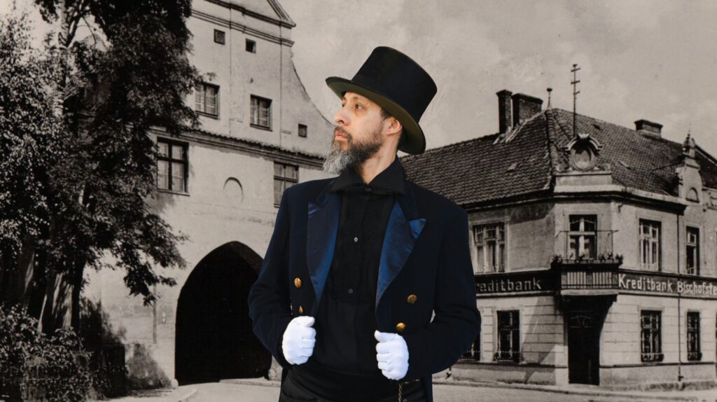 Mężczyzna w cylinderze na tle starego budynku.