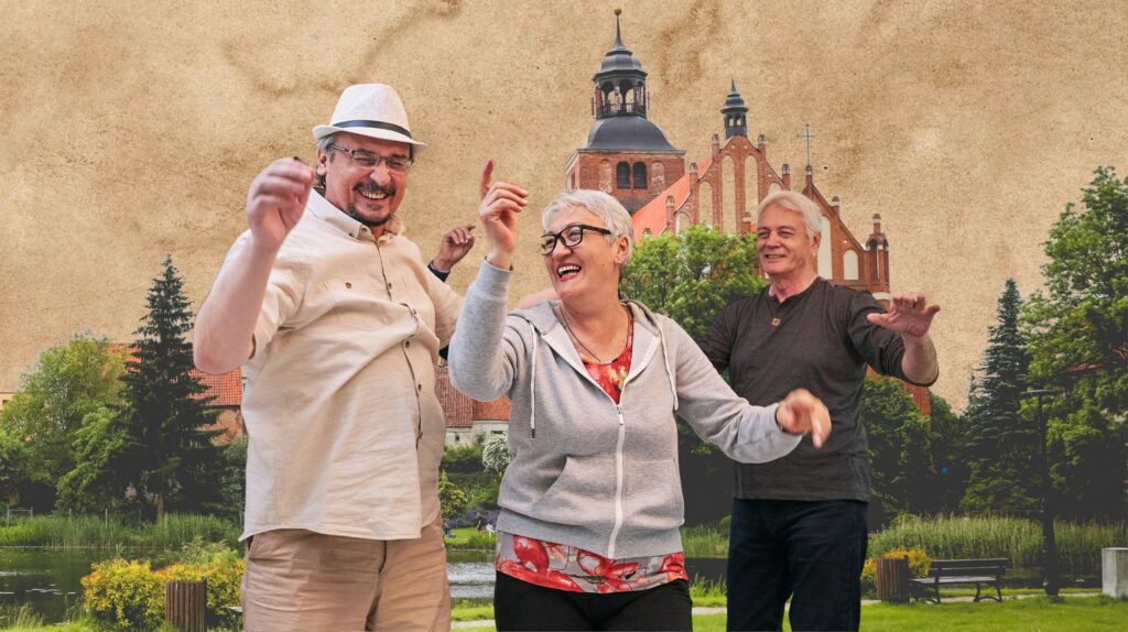 Trzy osoby tańczące przed tłem gmachu.