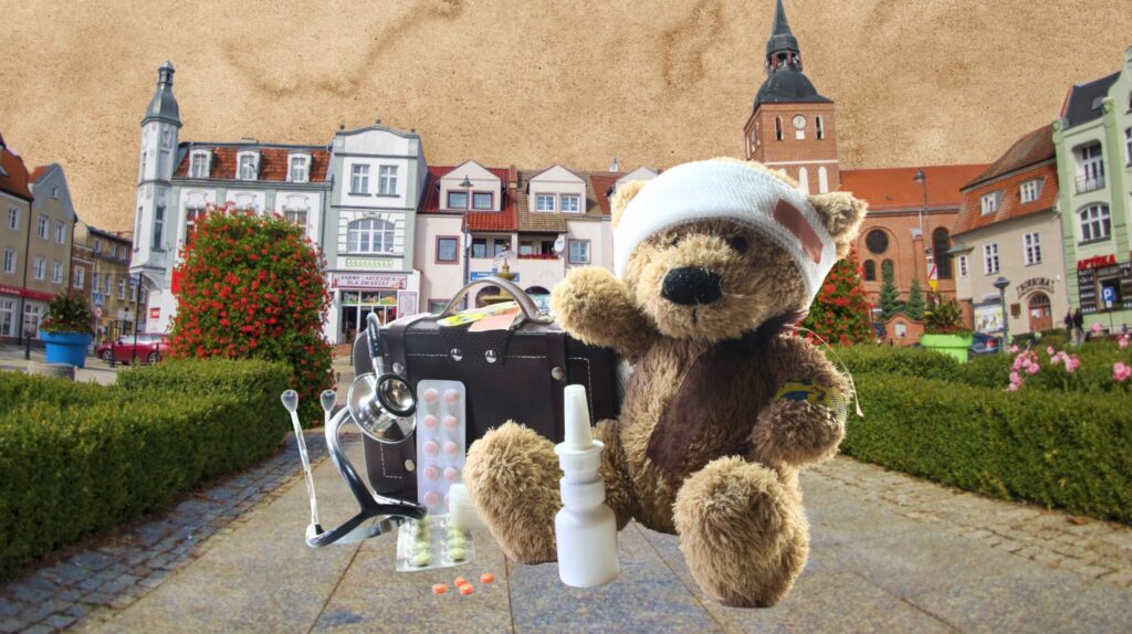 Maskotka misia w opatrunku z akcesoriami medycznymi na tle miasta.