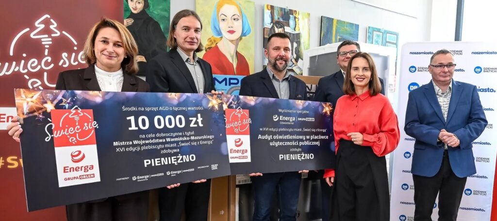 Grupa ludzi trzymająca plakaty z dotacją na cele dobroczynne.