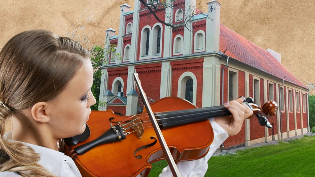 Młoda kobiet grająca na skrzypcach przed czerwoną budowlą