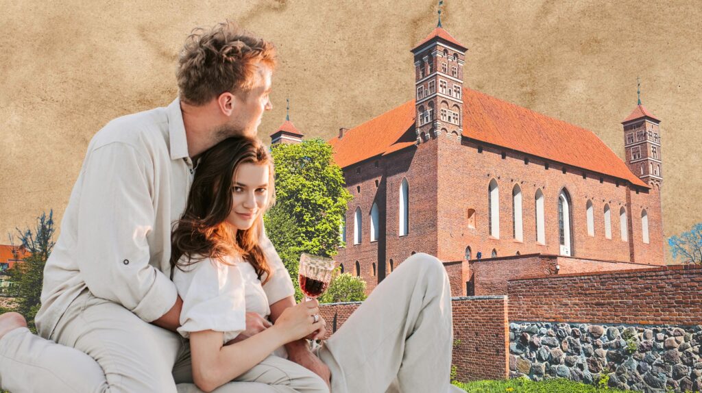 Para siedząca przed zabytkowym budynkiem.