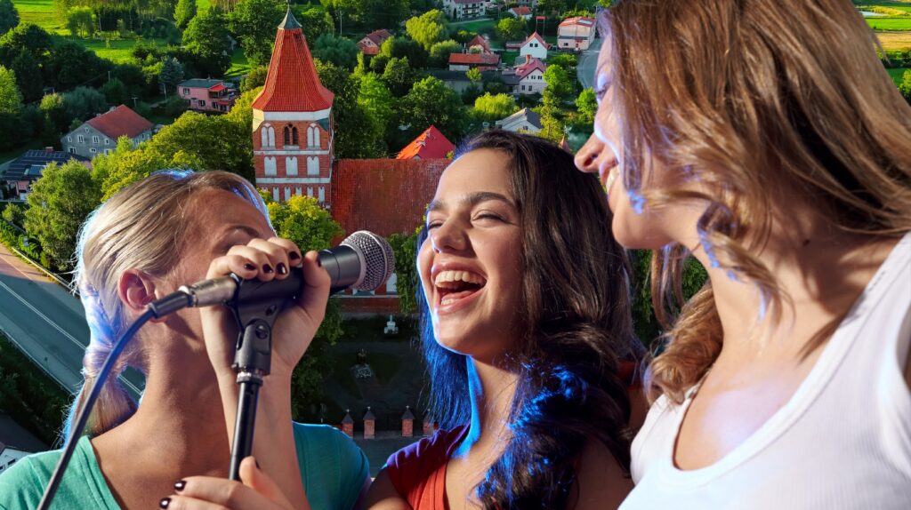 Trzy osoby śpiewają na tle krajobrazu.