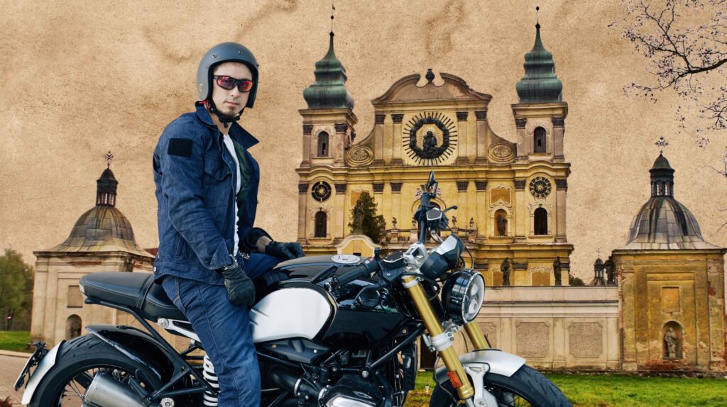 Mężczyzna na motocyklu przed budynkiem.