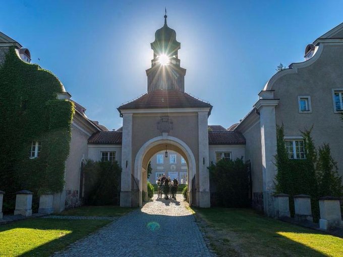 Brama prowadząca do historycznego budynku z oświetleniem słonecznym.