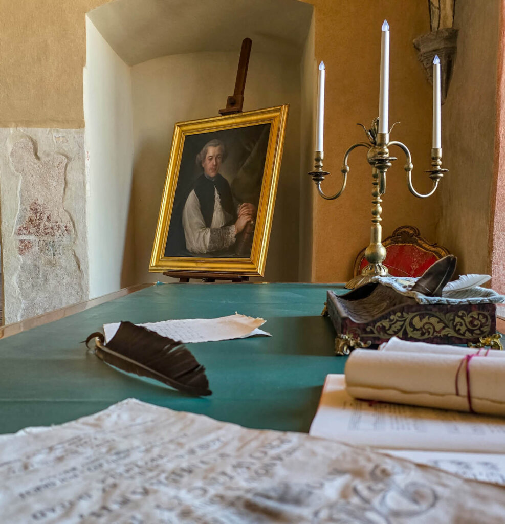 Gabinet z obrazem na sztaludze i świecznikiem.