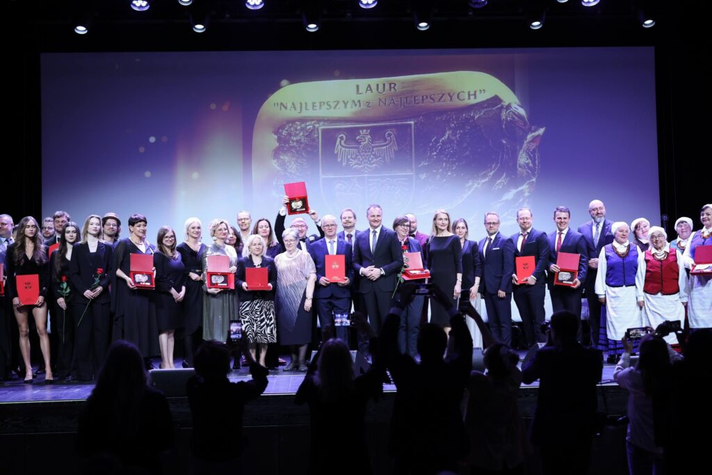 Grupa ludzi na scenie podczas ceremonii wręczenia nagród.