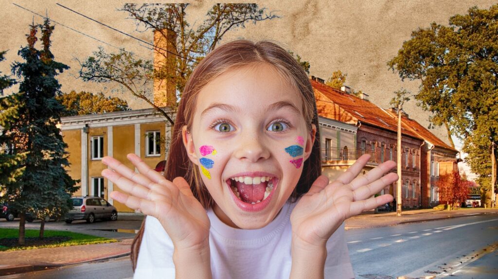 Uśmiechnięta dziewczynka z malunkami na twarzy.