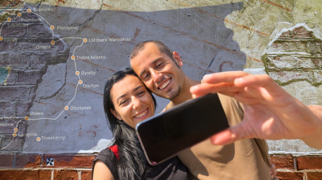 Para robiąca selfie na tle mapy