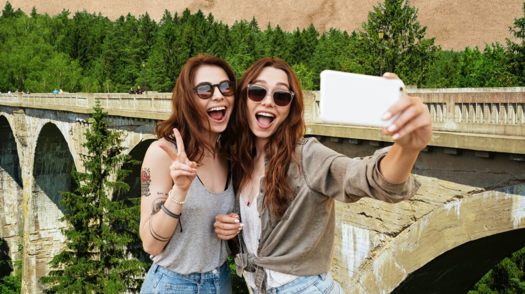 Dwie dziewczyny robią selfie na moście.