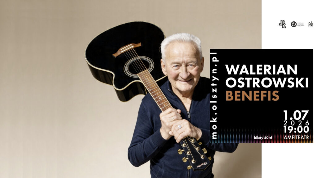 Uśmiechnięty, starszy mężczyzna trzymający na ramieniu gryf czarnej gitary akustycznej, obok czarnego bloku z napisem informującym o benefisie.