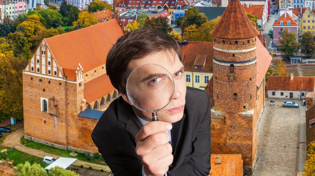 Mężczyzna trzymający szkło powiększające z tłem architektury.