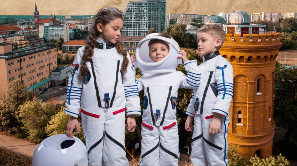 Dzieci w strojach astronautów na tle miasta.