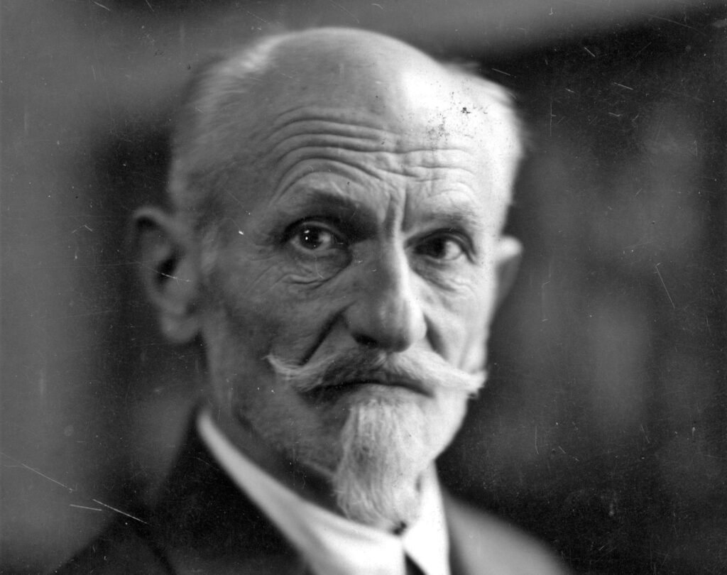 Czarnoskalny portret starszego mężczyzny z wąsami.