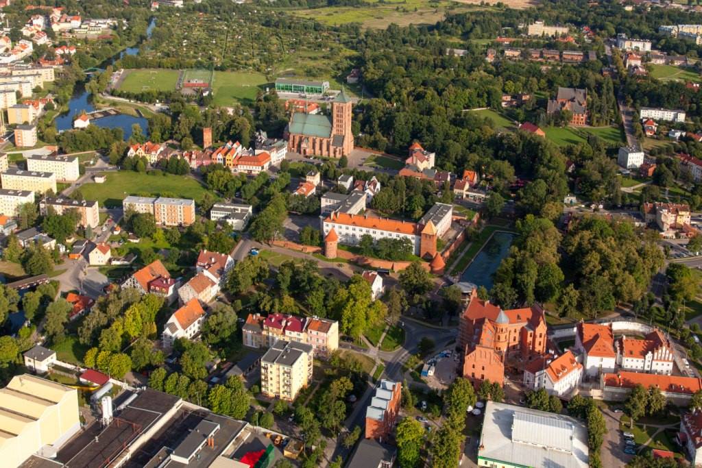 Widok lotniczy miasta z zielenią i budynkami.