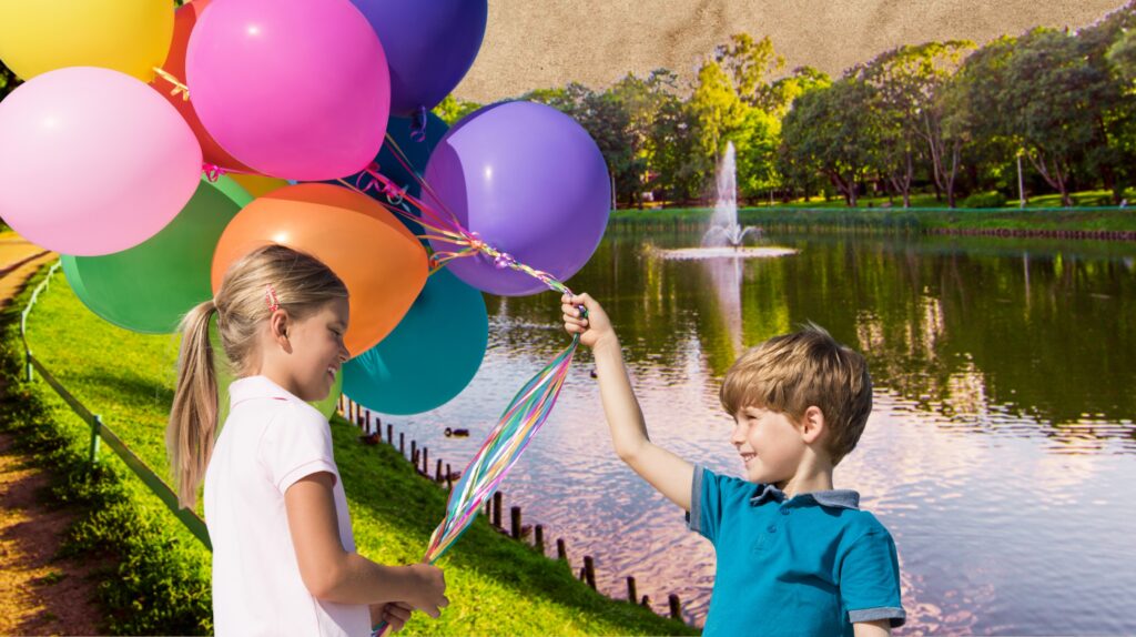 Dzieci trzymają balony nad jeziorem.