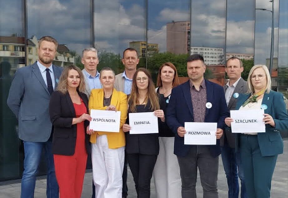 Grupa ludzi trzymająca plakaty z hasłami.