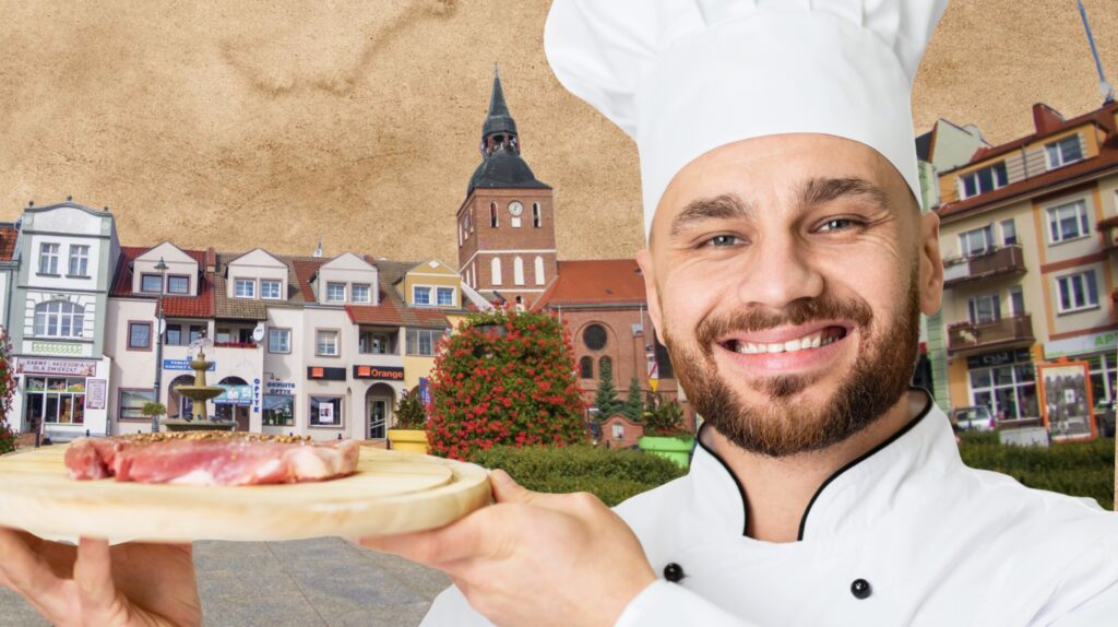 Uśmiechnięty kucharz trzymając tackę z mięsem.