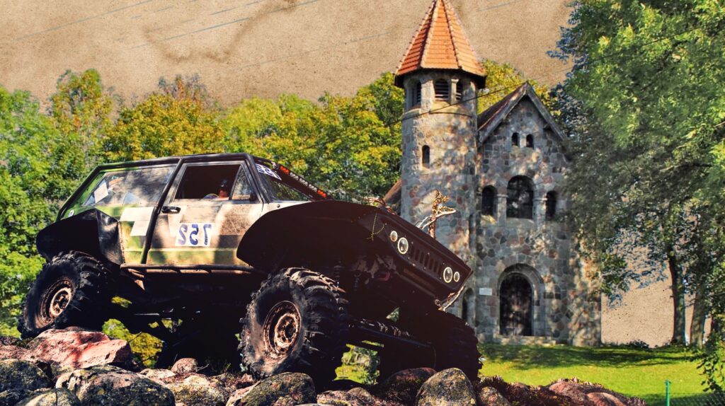 Off-road vehicle on rocky terrain with a stone building in the background.