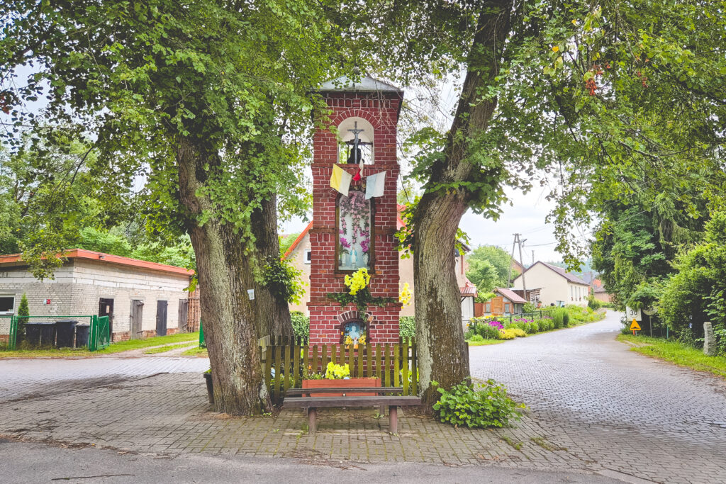 Pomnik otoczony drzewami w małej miejscowości.