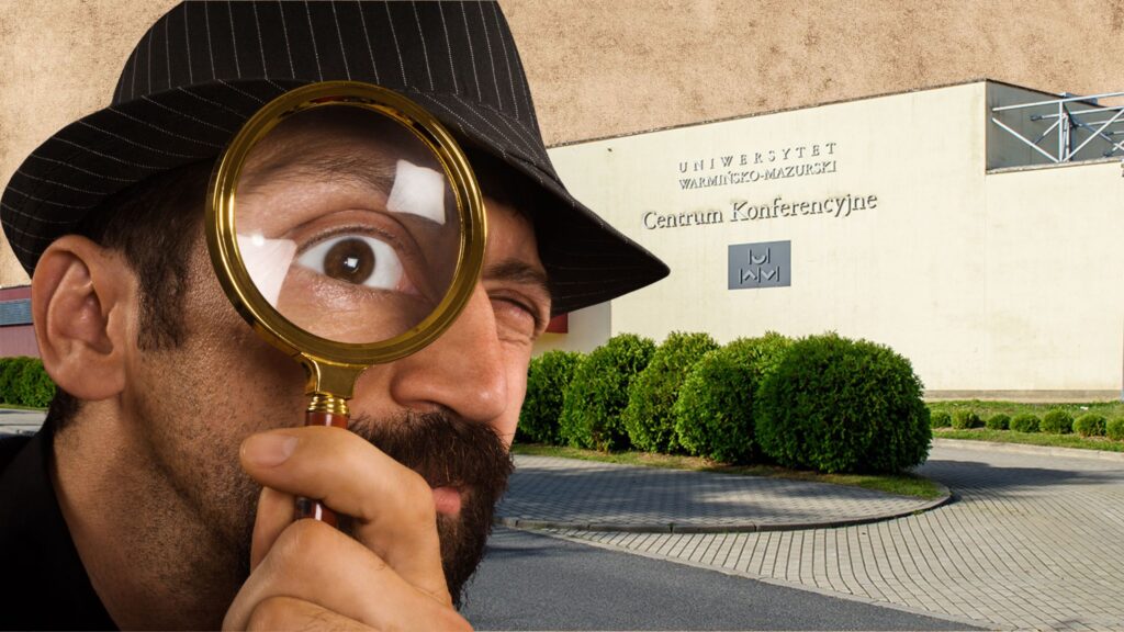 Mężczyzna w kapeluszu patrzy przez lupę na tle budynku Centrum Konferencyjnego Uniwersytetu Warmińsko-Mazurskiego.