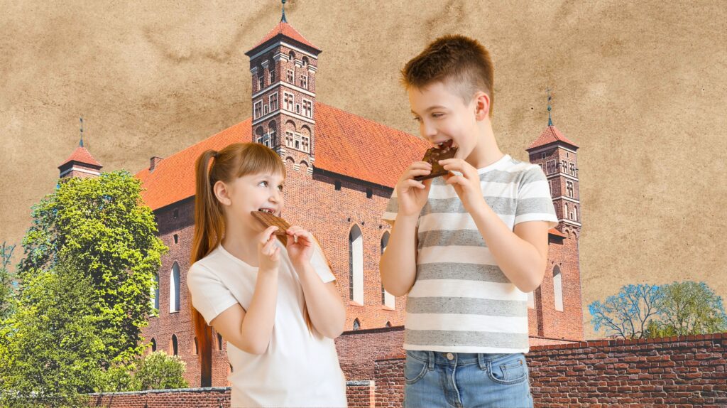 Dzieci jedzące ciasteczka przed zamkiem.