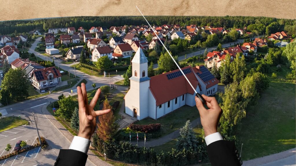 Widok na wieś z kościołem i osiedlem domów.