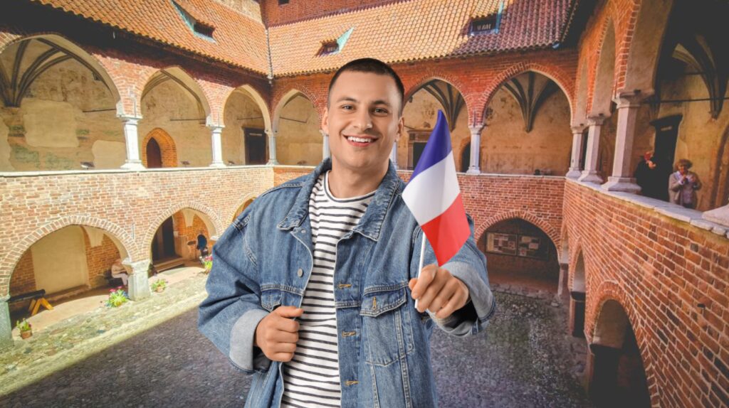 Mężczyzna trzymający flagę Francji w zamku.