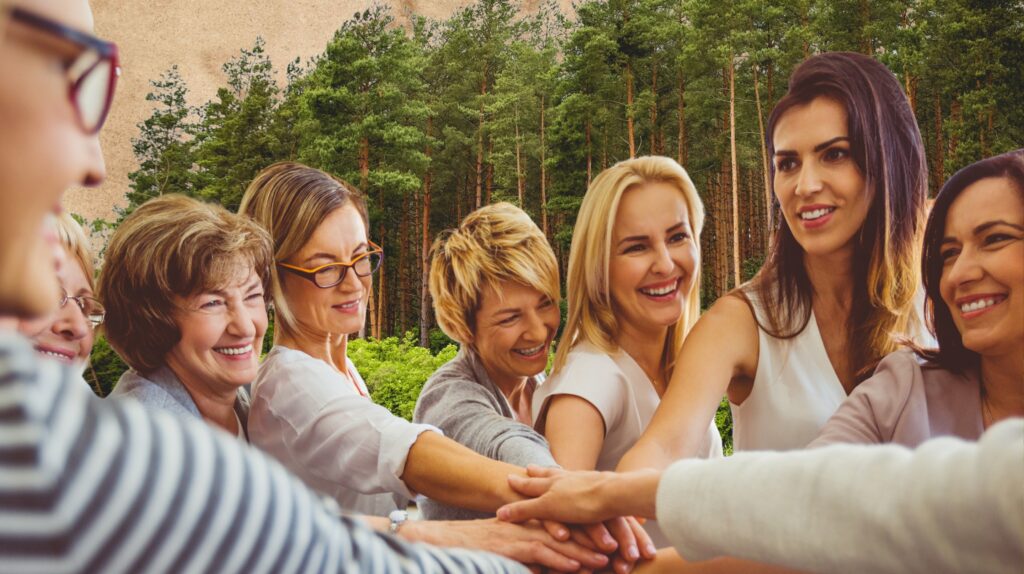 Grupa kobiet uśmiechających się i trzymających się za ręce.