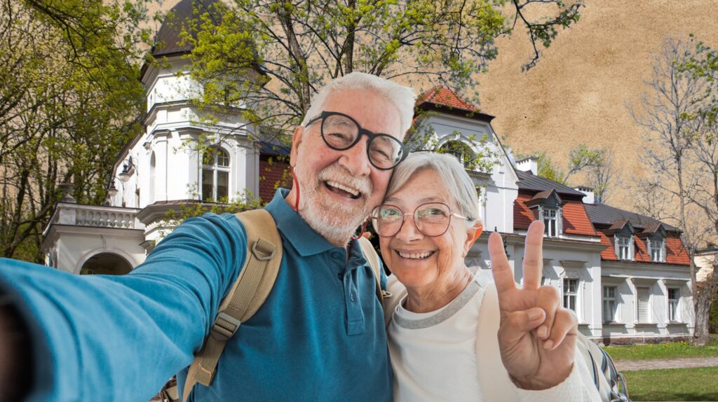 Starsza para robi selfie przed domem.