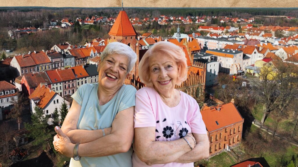 Dwie uśmiechnięte kobiety pozują przed miastem.