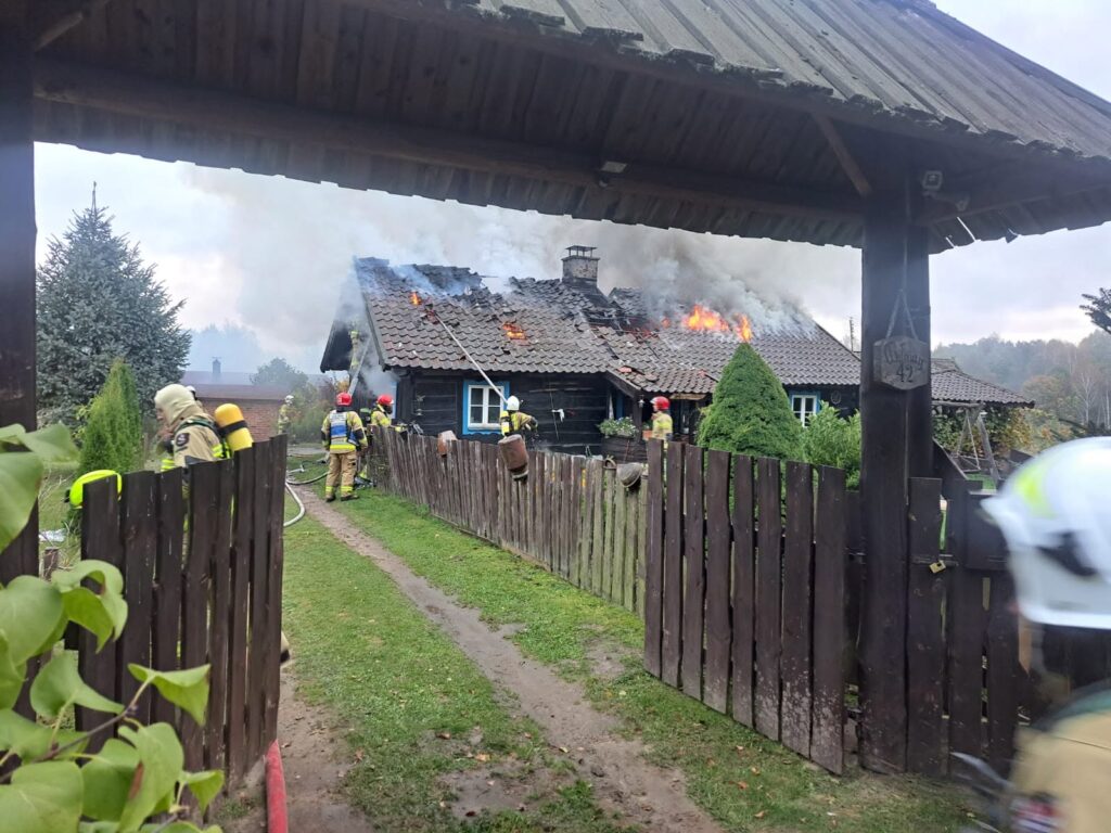 Płonący dom z udziałem straży pożarnej.